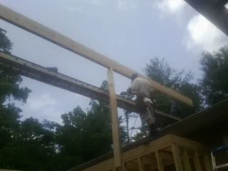Carpenter setting a ridge beam over a new addition frame — Ice Dam Removal by Roofing Brothers in Roan Mountain