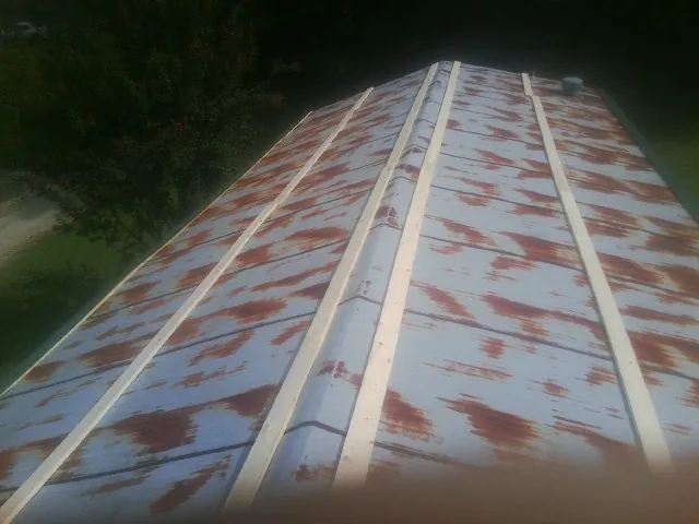 Rusted metal roof panels with new wood purlins before replacement — Storm Damage Roof Repair in Roan Mountain by Roofing Brothers