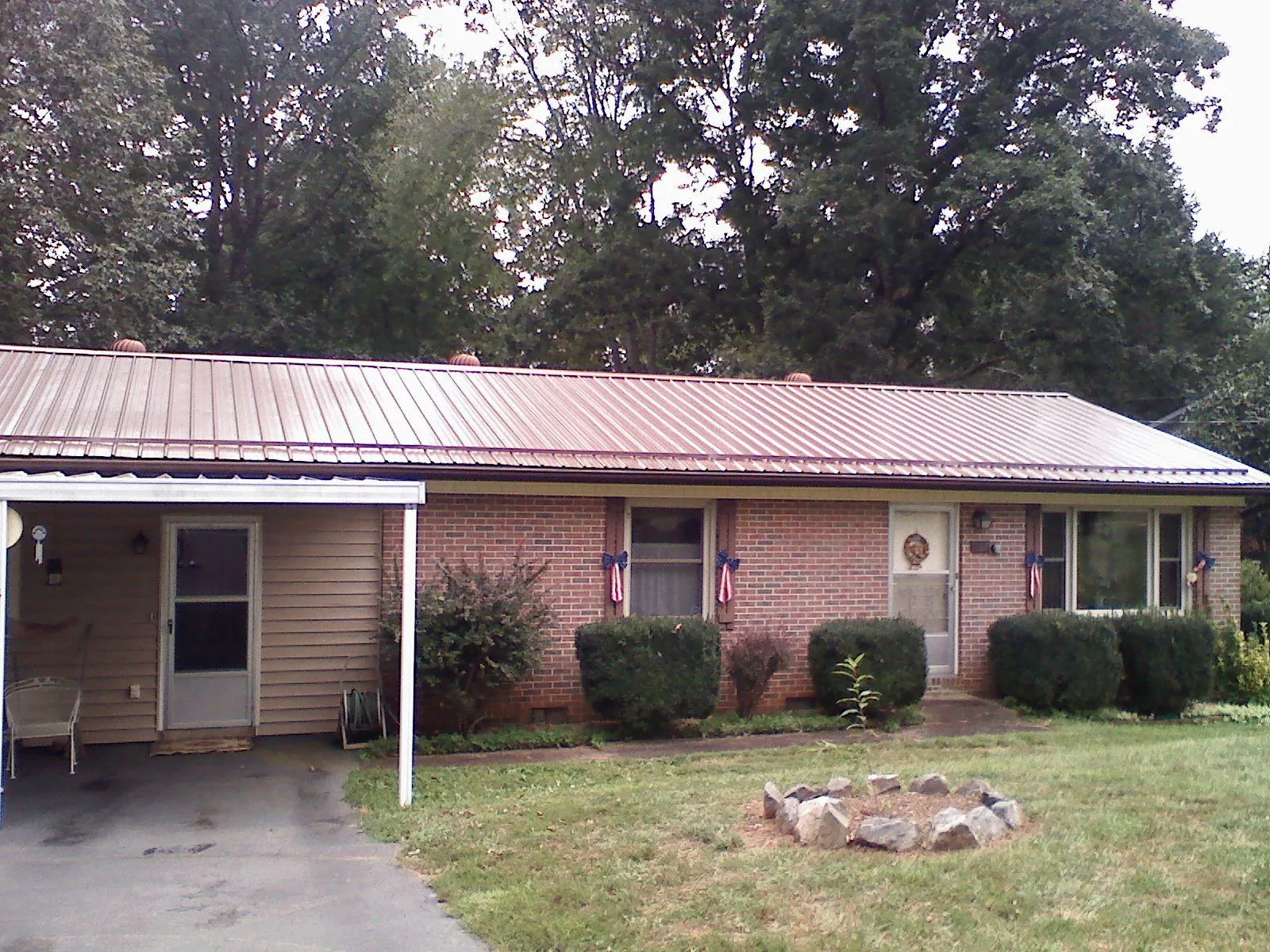 Bronze metal roof and carport on a brick ranch home — Roof Repair work by our crew in Roan Mountain